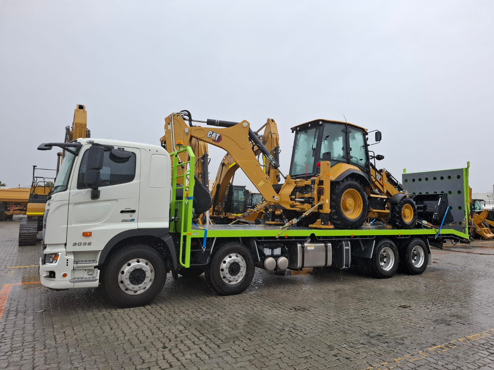 CAT backhoe loader on Hino 3036 flatbed