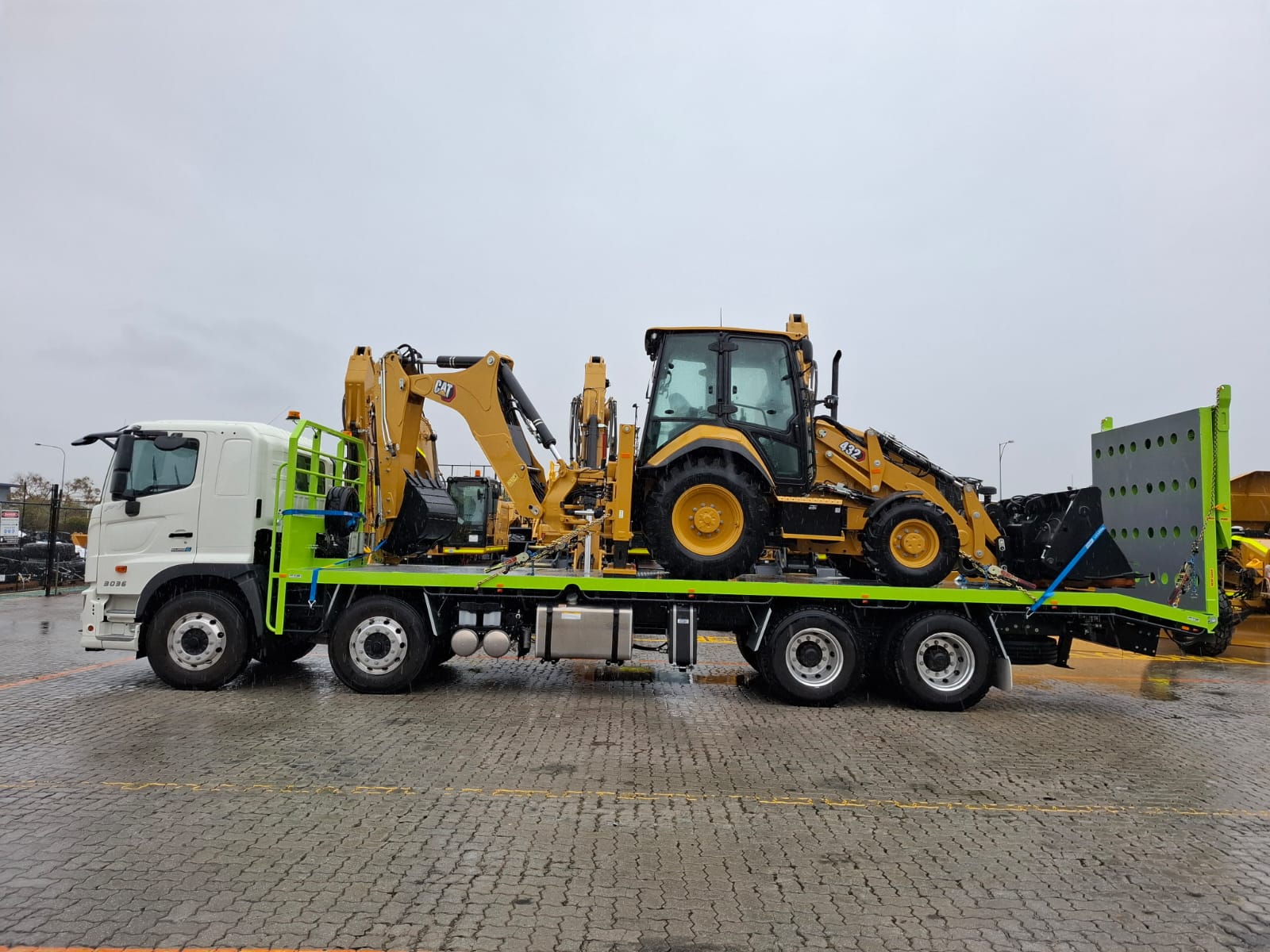 Two CAT backhoe loaders loaded on Ozwest Transport flatbed truck Perth
